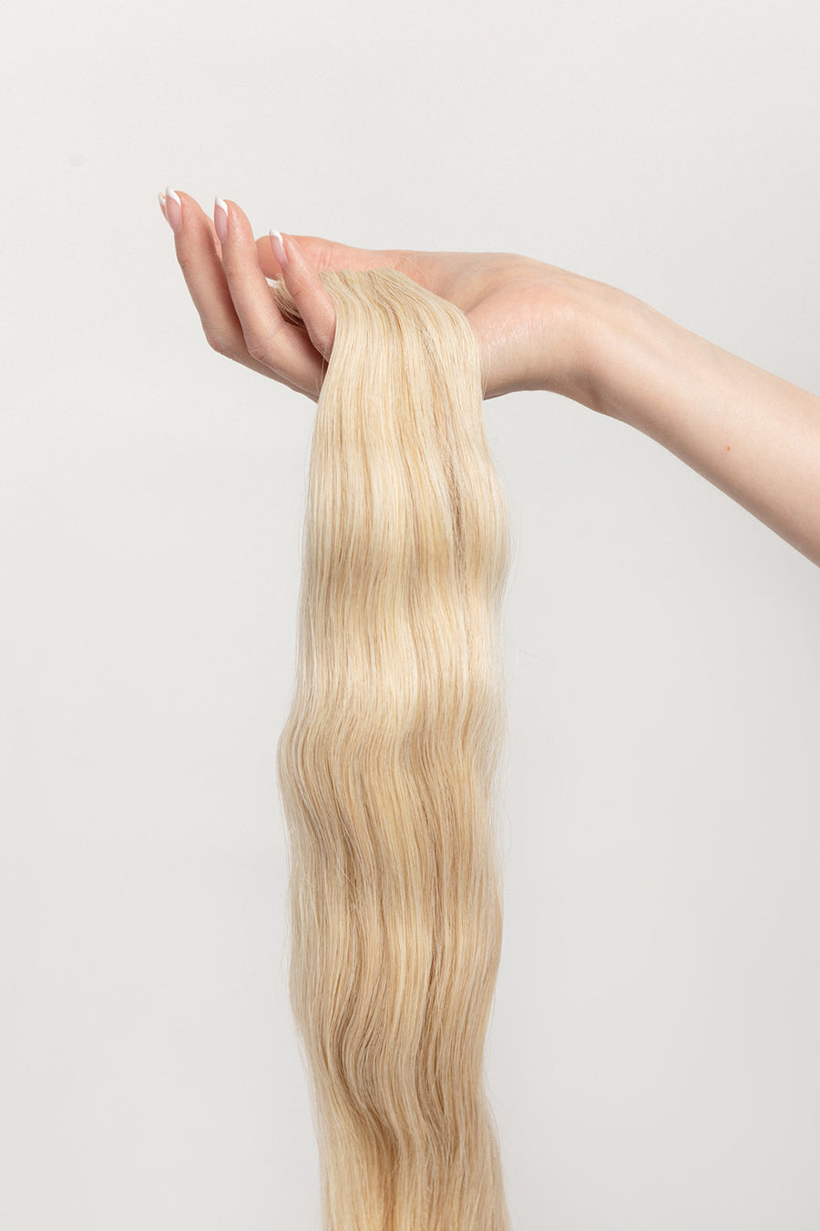 Honey is our dimensional blonde with warm undertones. This will have you feeling sweet like honey but stinging like a bee.   Stylist lingo: Natural/gold dimensional mix of levels 9 & 10 Harloc Tape-In Extensions are made from ethically sourced, premium, Remy Slavic Hair. These reusable hair extensions can be used to add length, volume, chemical-free colour, or to correct or enhance a haircut. Available in 16 beautiful shades. Combine multiple colours to create a custom colour blend and perfect match.