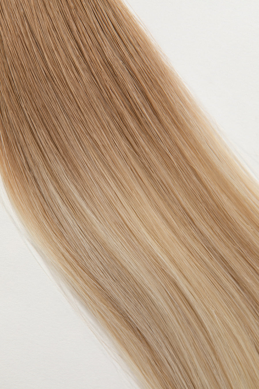 Soleil Sand is our golden blonde blend cascading from a Sand root.  Stylist lingo: Natural rooted level 8 blended into natural/gold dimensional levels 8 & 10 The Harloc Ponytail Extension is our clip-in ponytail that is made from ethically sourced, Remy Slavic hair. It is a quick way to instantly add length and volume to your ponytail and it comes in two lengths, 18-20” and 20-24”. It comes with a velcro base and clip to secure the ponytail.  Available in 10 of our beautiful shades.
